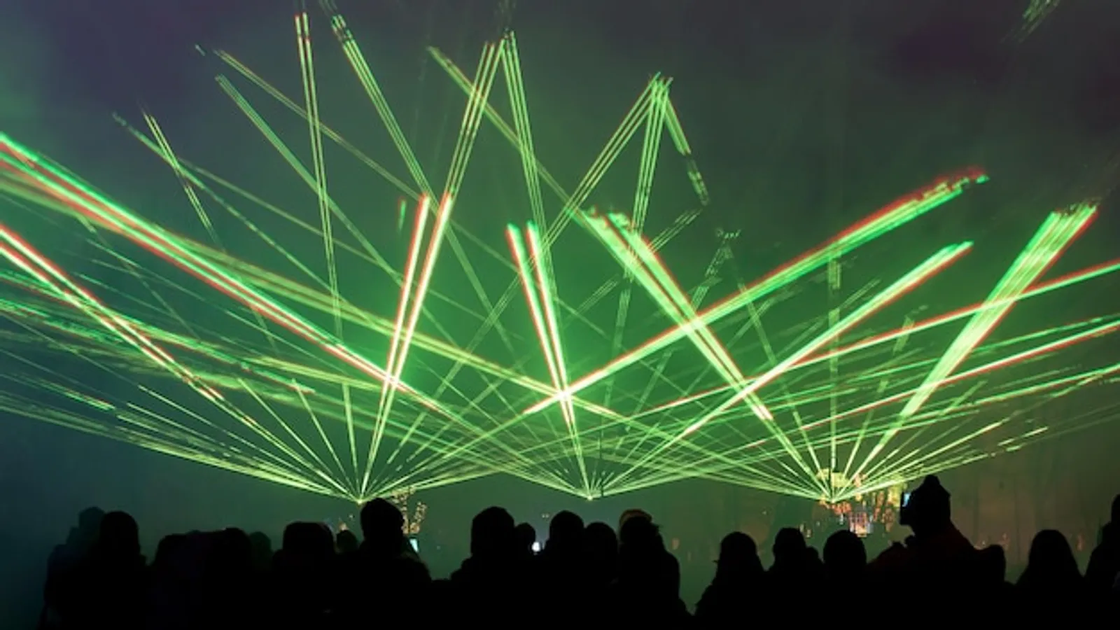 Kleine Open-Air-Bühne bei Dämmerung mit warmen Bühnenlichtern und Publikum